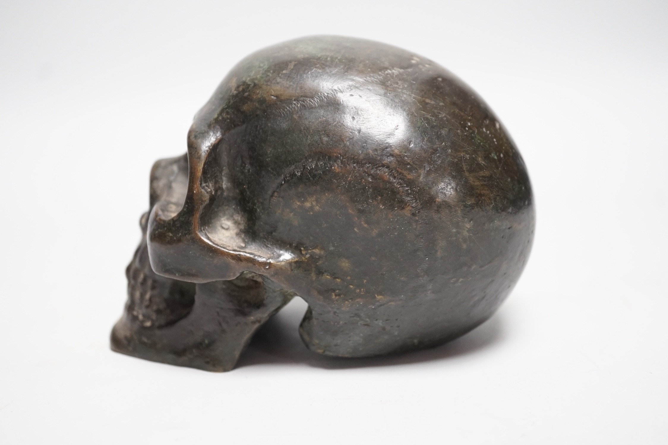 A bronze model of a skull, once part of a larger piece. 13cm deep